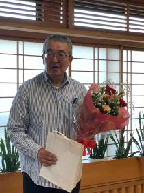 記念品と花束を手にする宇田川浩司副会長
