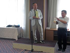 須賀隆夫 様（高22回）より<br>「特別賞の焼酎」について説明